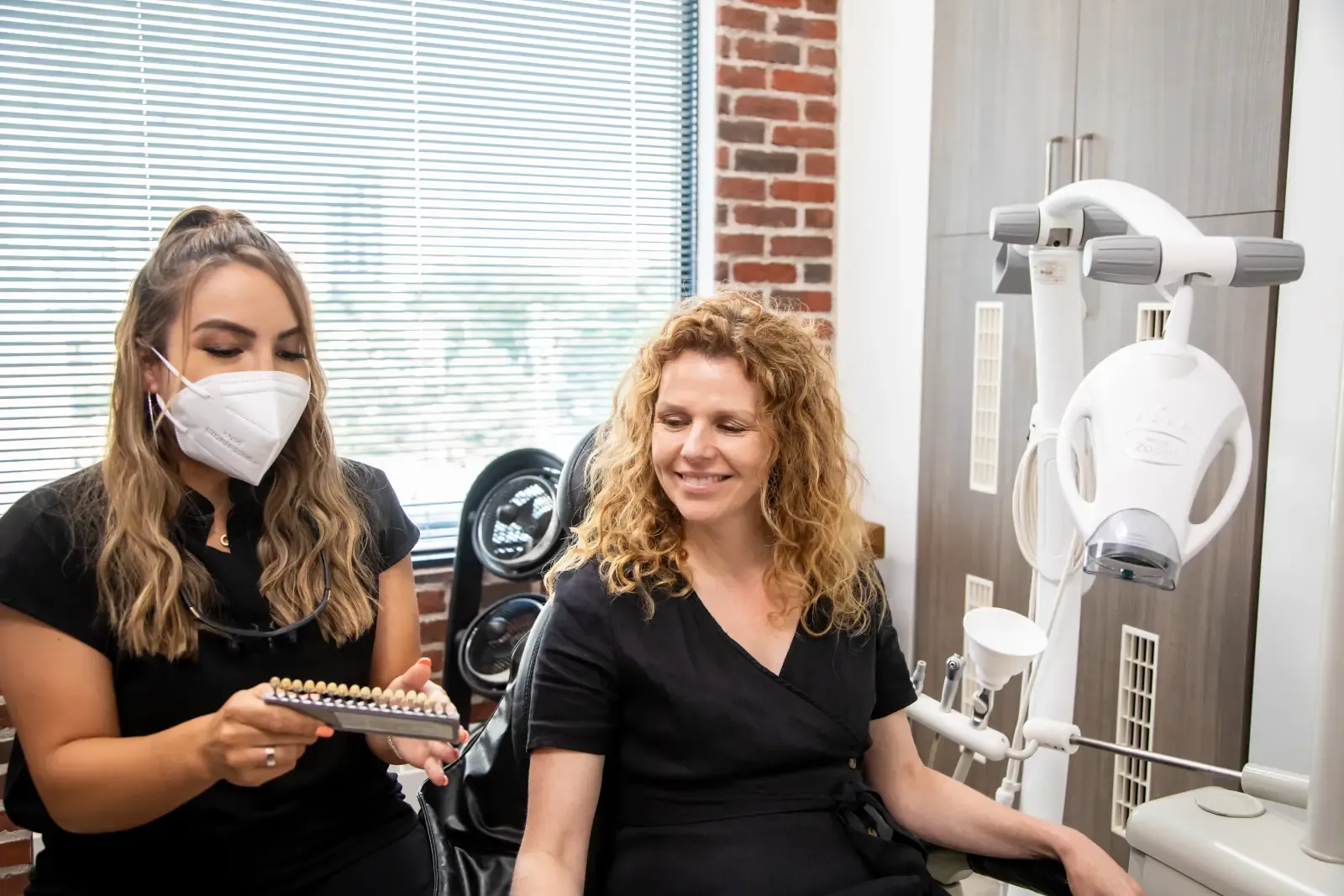 A Belman Dental Centre team member discussing tooth shades with a patient