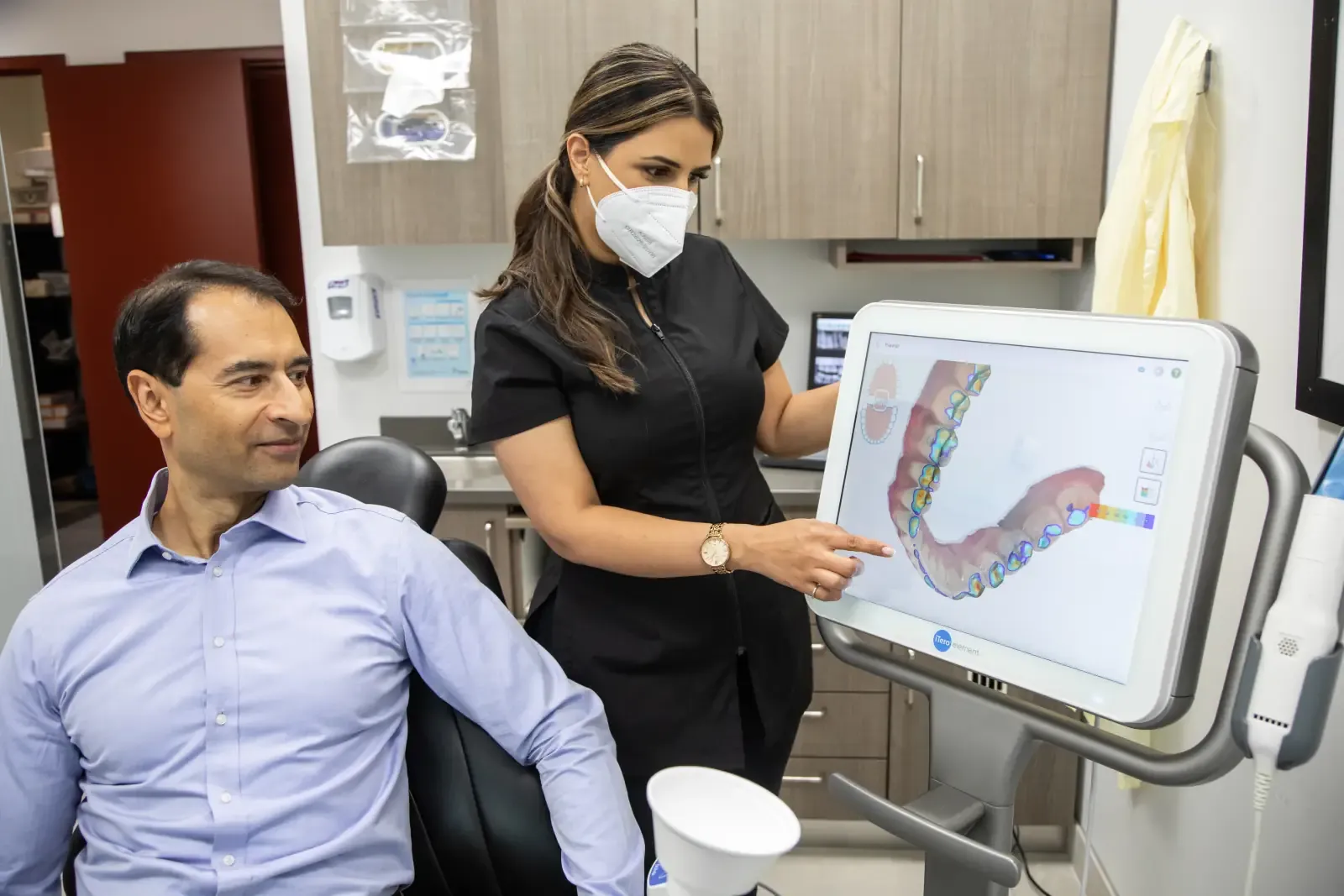 A Belman Dental Centre team member reviewing a digital scan with a patient